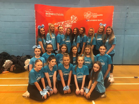 cheer leaders in front of active school banner